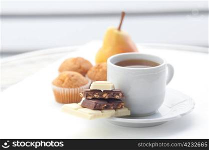 bar of chocolate,tea, muffin and pear