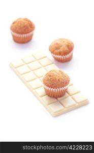 bar of white chocolate and muffin isolated on white