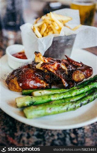 Barbecue chicken with asparagus and french fries
