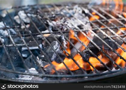Barbecue Fire Grill close-up, empty flaming charcoal grill with open fire, ready for product placement.. Barbecue Fire Grill close-up