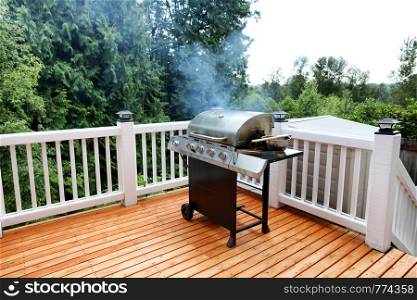 Barbecue grill cooking in open outdoor deck during summer day