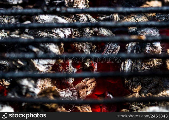 Barbecue grill pit with glowing and flaming hot charcoal briquettes