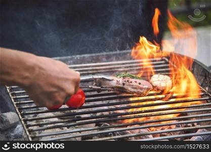 Barbecue hot grilled meat with fire flame heat bbq cooking dinner burn from charcoal. Roast steak grilling with fire and smoking cooking outside. Beef grilling outdoor for party. Western food concept