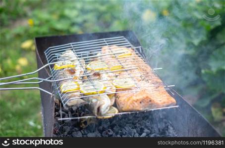 Barbecue outdoors with grilled salmon and gilt-head bream