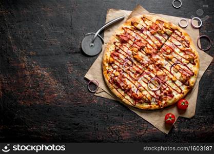 Barbecue pizza with bacon, chicken and sauce. On dark rustic background. Barbecue pizza with bacon, chicken and sauce.