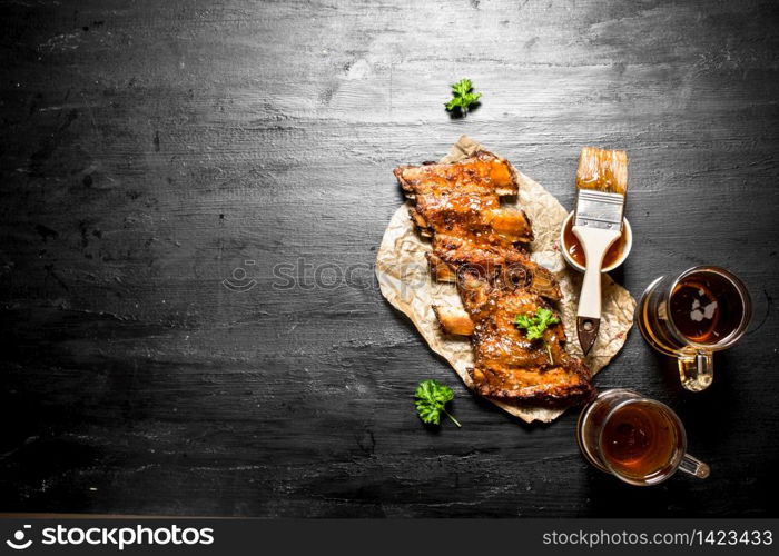 Barbecue pork ribs with beer and sauce. On the black chalk Board.. Barbecue pork ribs with beer and sauce.