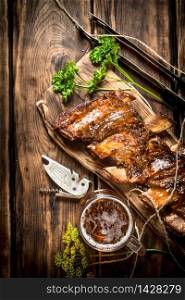 Barbecue ribs with a cold beer. On a wooden table.. Barbecue ribs with a cold beer.