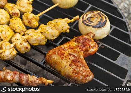 barbecue with chicken wing, meat skewer and ham