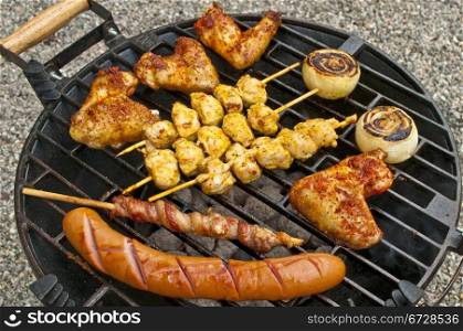 barbecue with chicken wings,Bratwurst, meat skewer and ham
