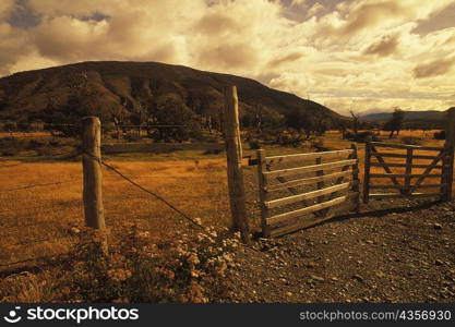 Barbed wire fence with a gate on a landscape