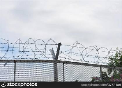 Barbed wire fence with metallic net