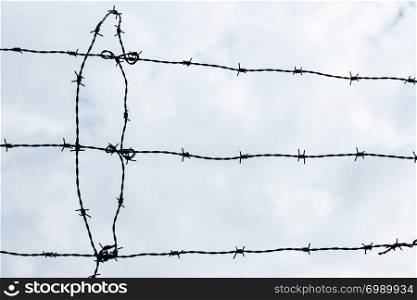 Barbed wire over cloudy sky abstract background
