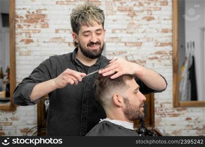 Barber cutting hair with scissors to a handsome young man . High quality photography. Barber cutting hair with scissors to a handsome young man .