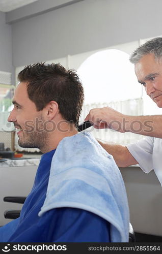 Barber cutting mans hair in barber shop