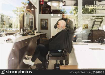 barber doing haircut bearded aged client hair salon