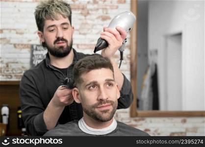 Barber drying hair of customer. High quality photo. Barber drying hair of customer