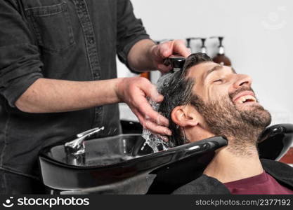 Barber shop. Hairdresser man washes client head in barbershop. High quality photography. Barber shop. Hairdresser man washes client head in barbershop