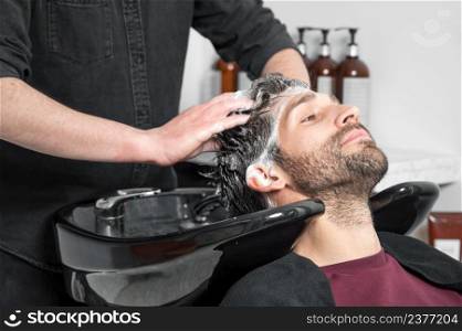 Barber shop. Hairdresser man washes client head in barbershop. High quality photography. Barber shop. Hairdresser man washes client head in barbershop