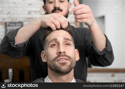 Barber shop. Man in barber&rsquo;s chair, hairdresser styling his hair. High quality photography. Barber shop. Man in barber&rsquo;s chair, hairdresser styling his hair