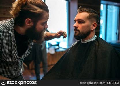 Barber styling mustache and beard at the barbershop. Hairdressing concept