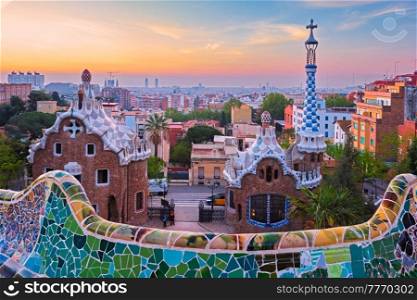 Barcelona city view from Guell Park with colorful mosaic buildings in tourist attraction Park Guell in the morning on sunrise. Barcelona, Spain. Barcelona city view from Guell Park. Sunrise view of colorful mosaic building in Park Guell