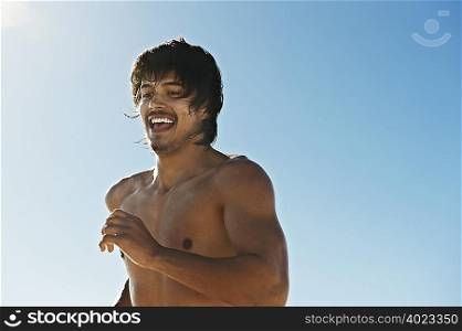 Bare chested man running in sunlight