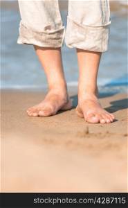 bare feet in the men&rsquo;s linen trousers near the sea