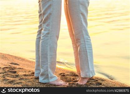 bare feet kissing couple at the sea
