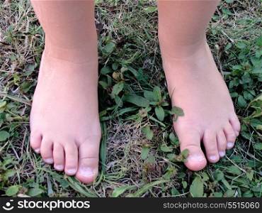 Bare feet of a baby on a green lawn
