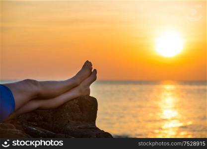 Bare human feet on beautiful sea sunset background. Summer vacation concept
