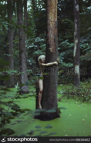 Bare lady hugging large tree in marsh scenic photography. Picture of person with wild forest on background. High quality wallpaper. Photo concept for ads, travel blog, magazine, article. Bare lady hugging large tree in marsh scenic photography