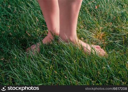 Barefoot Girl Standing On Grass. Nature Health Energy Concept. Copyspace On Forefround.. Nature Health Energy Concept, Barefoot Girl Standing On Grass
