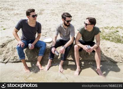 barefoot males chatting sandy beach