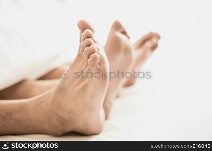 Barefoot of lovers under blanket in bedroom. Vacation and Happiness of sexual. Valentines day theme. Holiday morning theme