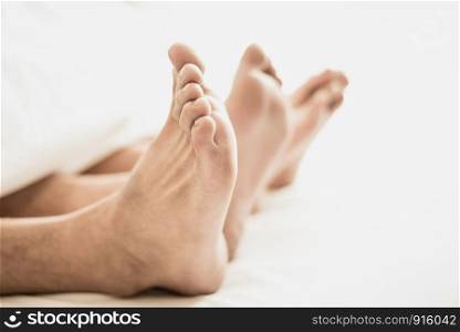Barefoot of lovers under blanket in bedroom. Vacation and Happiness of sexual. Valentines day theme. Holiday morning theme