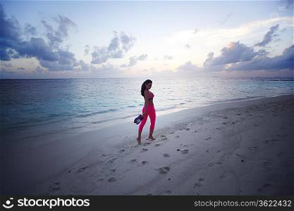 Barefoot woman walking along the beach