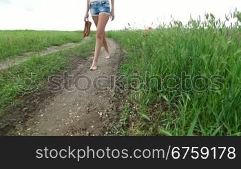 Barefoot Young Woman Walking A Country Road