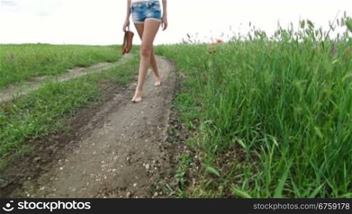 Barefoot Young Woman Walking A Country Road