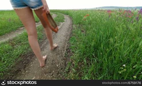 Barefoot Young Woman Walking Down A Country Road