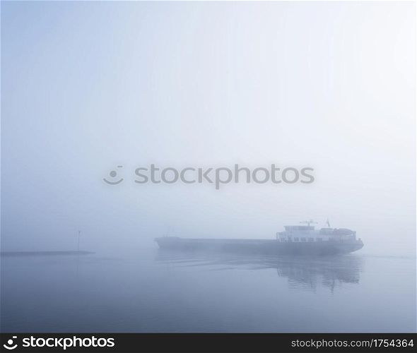 barge in the fog on river rhine near utrecht in the netherlands