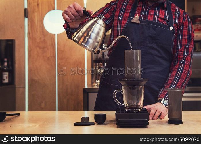 Barista brewing aeropress coffee. Barista brewing coffee in aeropress in the cafe