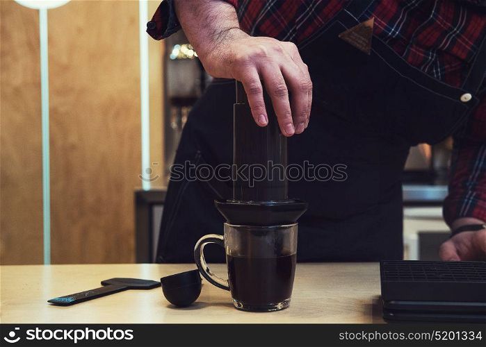 Barista brewing aeropress coffee. Barista brewing coffee in aeropress in the cafe