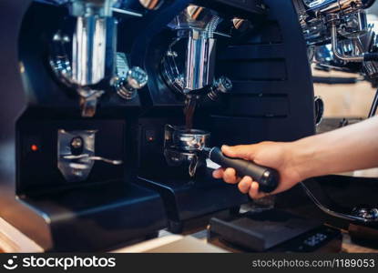 Barista hand pours beverage from coffee machine. Professional espresso preparation by bartender. Barista hand pours beverage from coffee machine