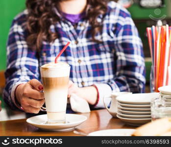 Barista is making sweet spicy latte on the bar stand. Barista is preparing latte