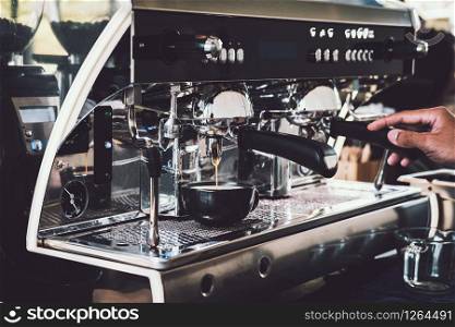Barista making coffee with professional coffee machine in cafe