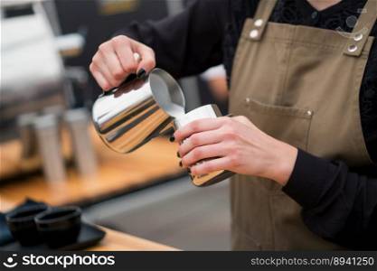 barista pours milk into a cup