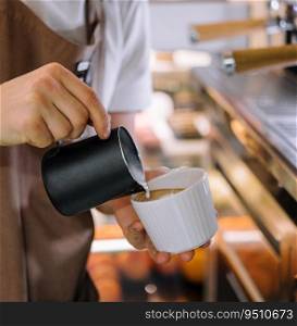 Barista pours milk into coffee