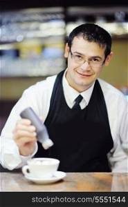 Barista prepares cappuccino in his coffee shop