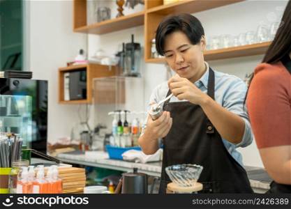 Barista using a coffee maker to coffee,Cafe worker making a coffee,Cafe owner in apron making coffee.