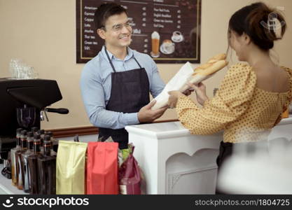 Baristas hand taking cup of hot coffee and bakery to offering to customer in coffee shop